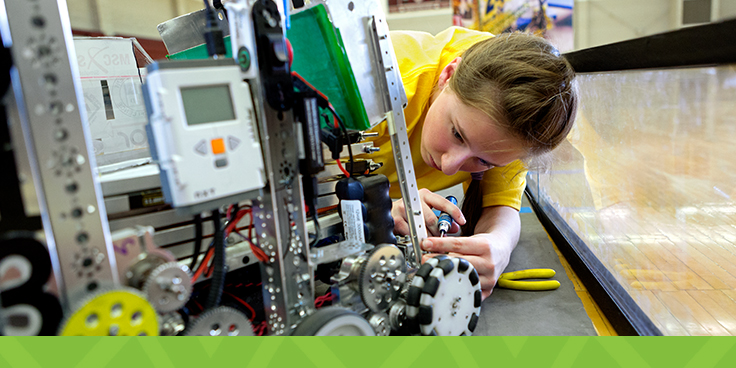 teen girl fixing robot